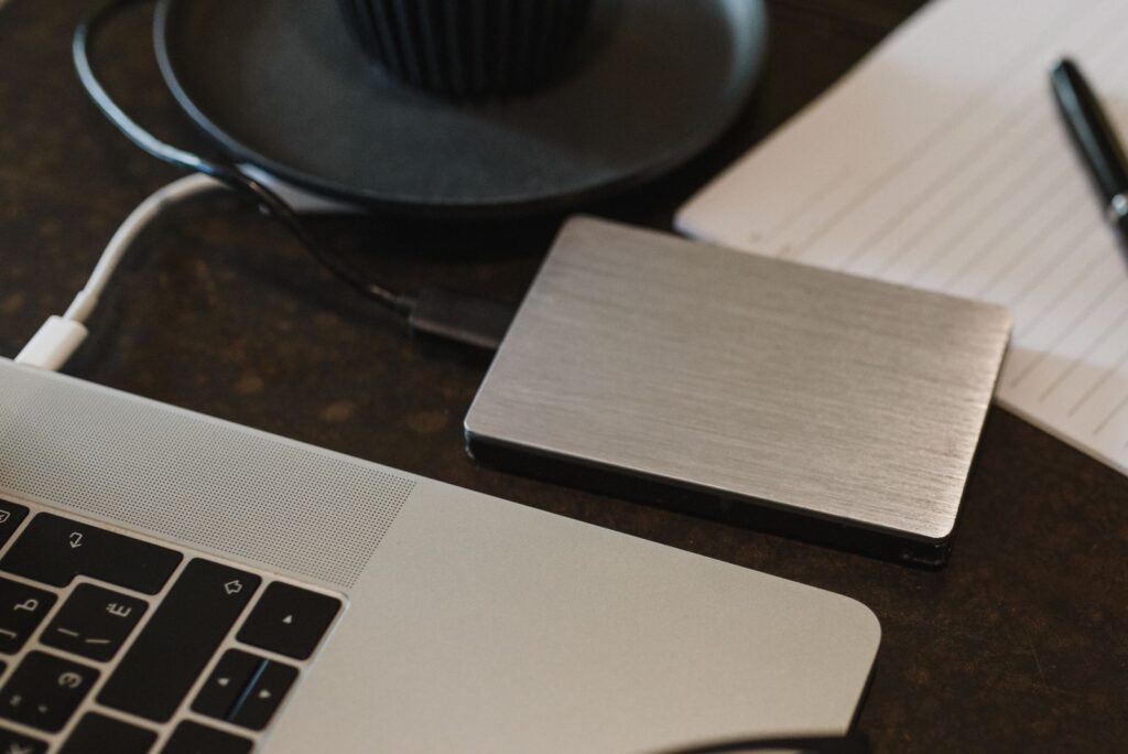 An external hard drive plugged into a laptop to back up your computer