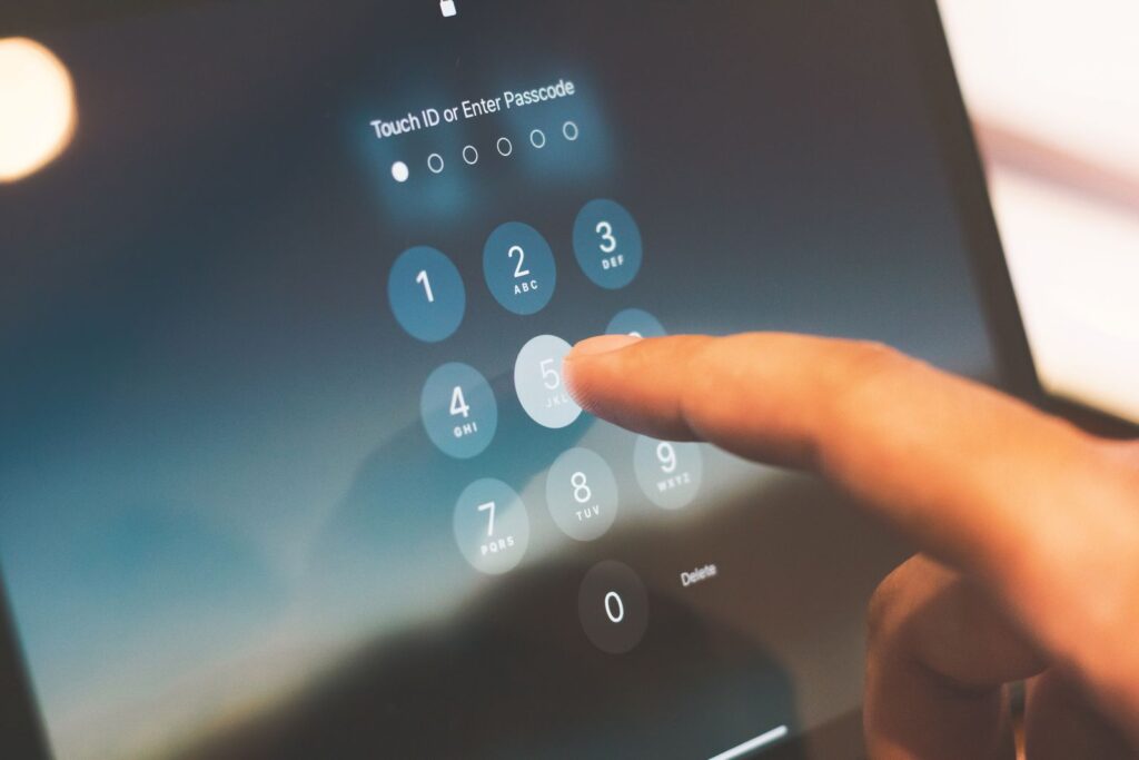 A finger entering a security code on a smartphone to complete two-factor authentication