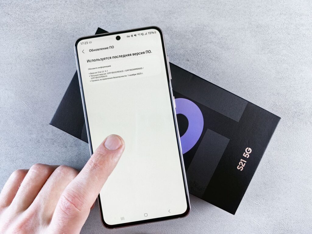 A finger tapping a software update prompt on a smartphone screen
